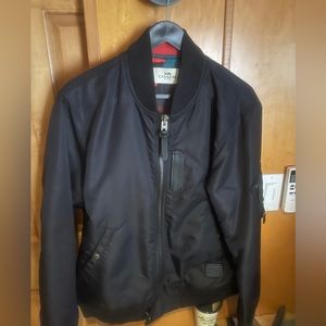 Coach Bomber Jacket, size medium, black outside with camouflage pattern inside.